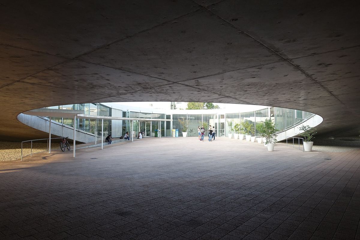 Innenhof unter dem geschwungenen Betondach des Rolex Learning Center auf dem EPFL-Campus